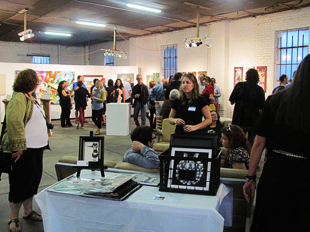 Attendees view art from current and former UIS students, as well as other local artists during the "Breaking In" opening at The Pharmacy.