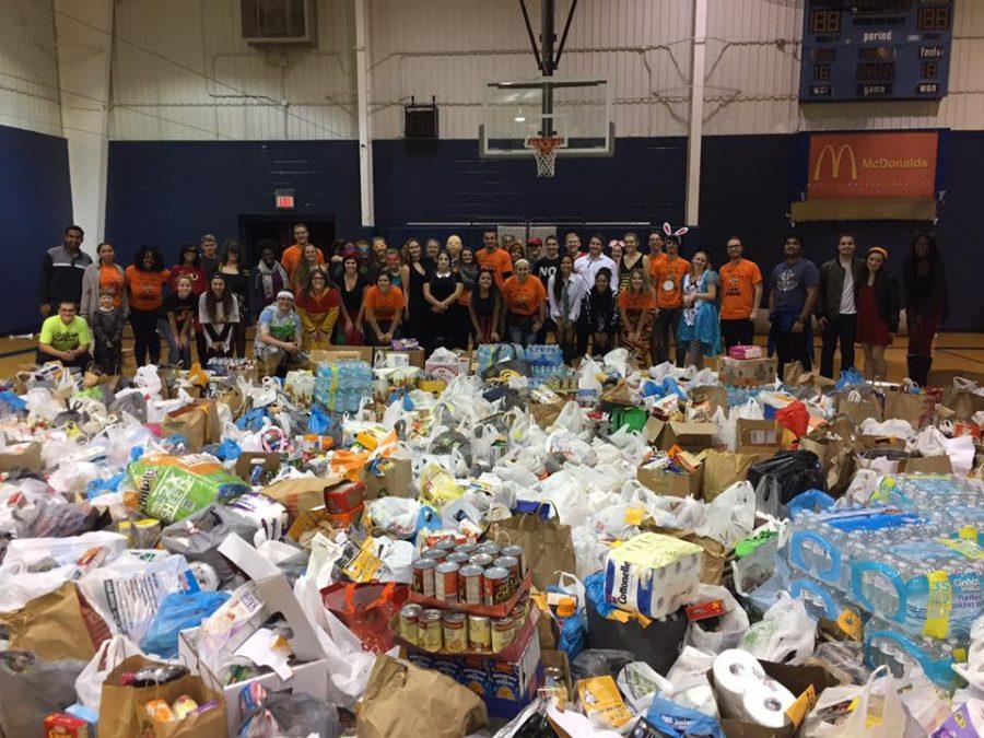 Volunteers pose for a photo behind 14,084 lbs of food collected for the Central Illinois Foodbank.