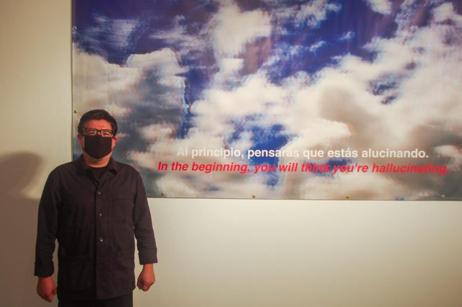 José Guadalupe Garza standing next to his 2019 piece “Sin Fronteras/Stateless (still from nonexistent film).”