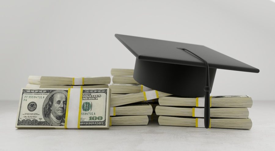 Graduation cap atop stacks of one hundred dollar bills | Photo Credit: Pixabay License 