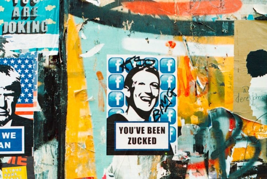 Mark Zuckerberg meme stickers on top of street art. | Photo Credit: Photo by Jeremy Bishop on Unsplash