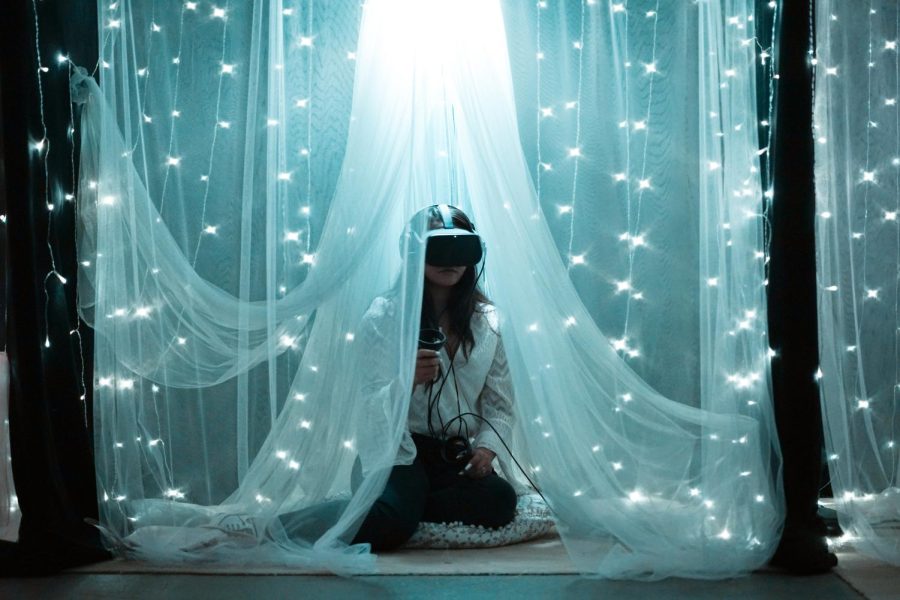 A young lady plays VR under string lights | Photo Credit: Barbara Zandoval on Unsplash