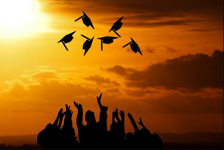 Photo of graduating class tossing caps in the air. | Photo Credit: Mohamed Hassan