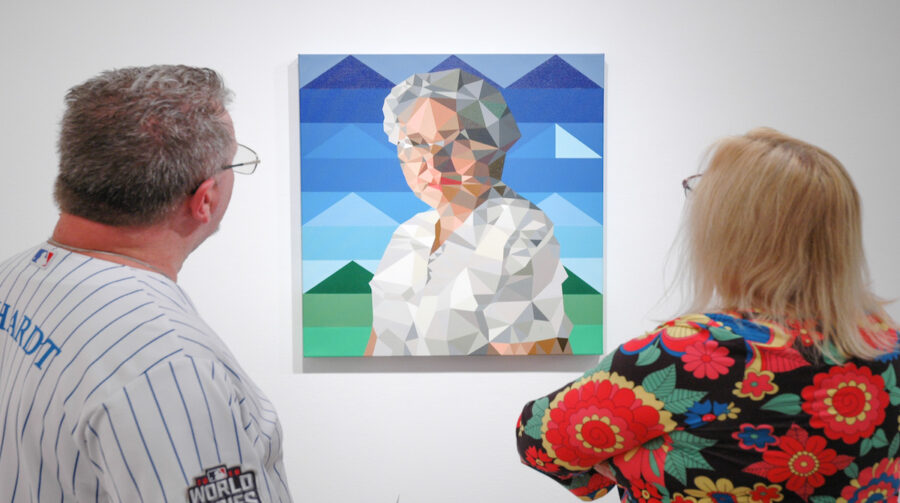 Gallery viewers examining A portrait of Mauricio Ramirez’s grandmother. Photo Credit: Jae Scott