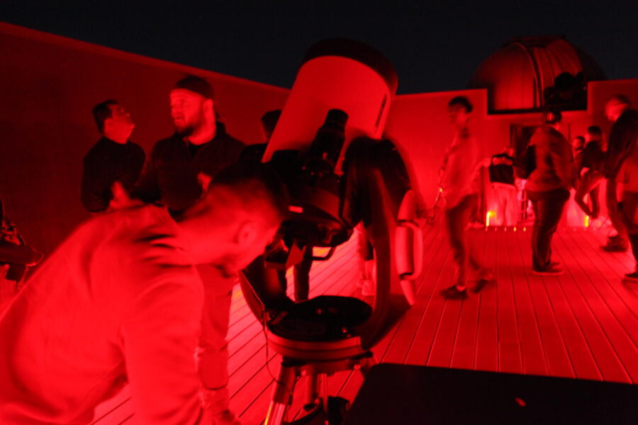 Star party attendee looking through the 12-inch telescope - pointed at Messier 13, a star cluster in the constellation of Hercules. Photo Credit: Regina Ivy