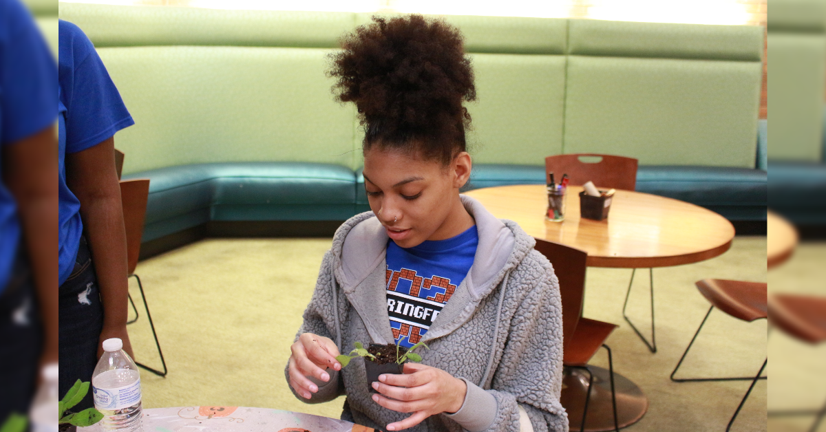 UIS student holding a seed pot | Photo credit: Bwayisak Tanko