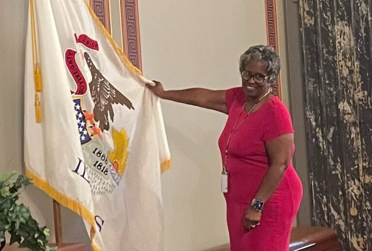 State Sen. Doris Turner, D-Springfield, holds up an Illinois state flag inside the Senate chamber in Springfield on Wednesday, July 19, 2023. Turner sponsored a bill in the state legislature that would create a commission tasked with exploring whether Illinois should adopt a new state flag design. Photo by Ann Strahle/UIS