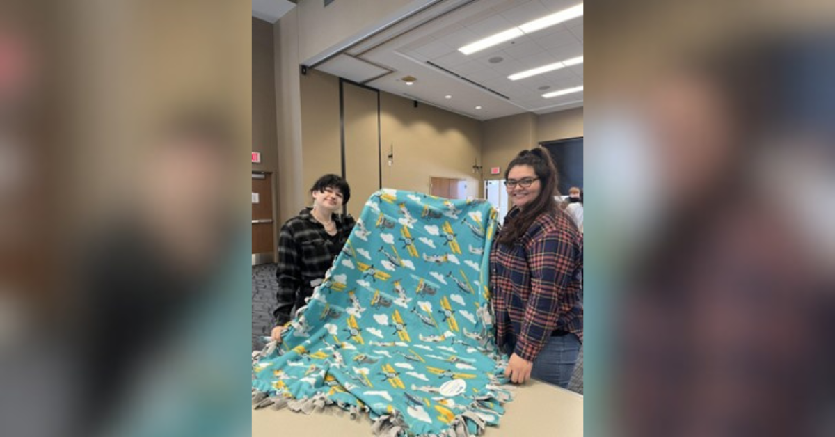 Sidekicks Fatima Velasco and Teadora Bowen presenting a finished blanket. | Photo Credit: Sydney Deweese