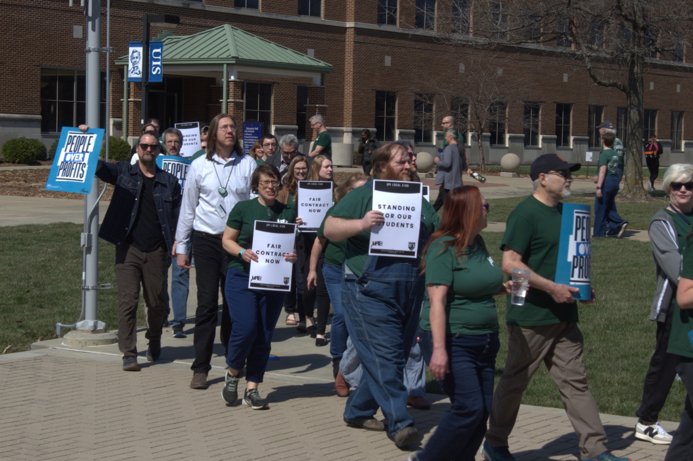 Members of the UIS United Faculty union, the UIS Support Staff union, students and community members march outside the Student Union on March 19, after the conclusion of the strike authorization voting period.
