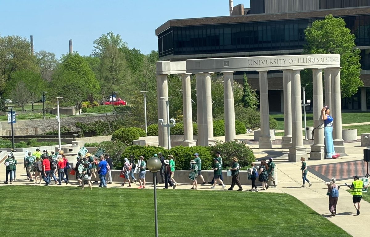 UIS professors and other supporters march past the Colonnade on Friday, April 17, 2026, during the 15th day of the professors' strike.